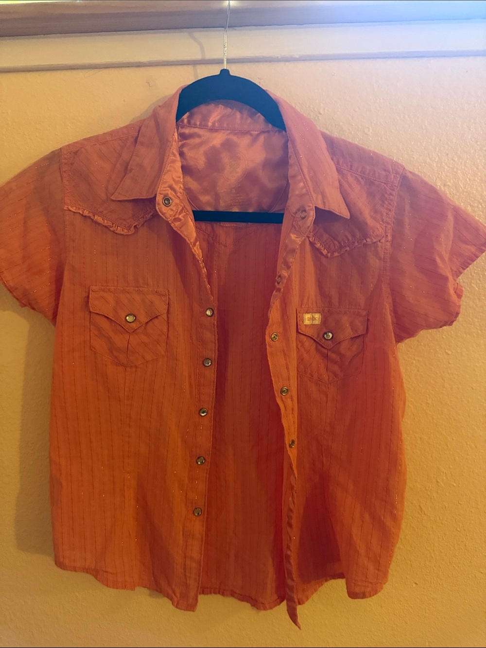 Cute peach colored western shirt .
